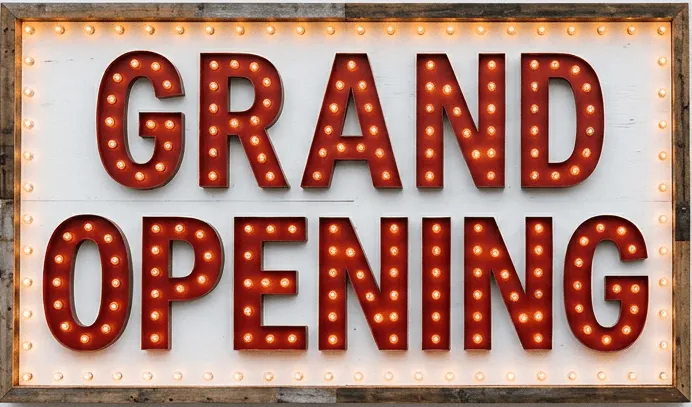 A lit-up Grand Opening sign